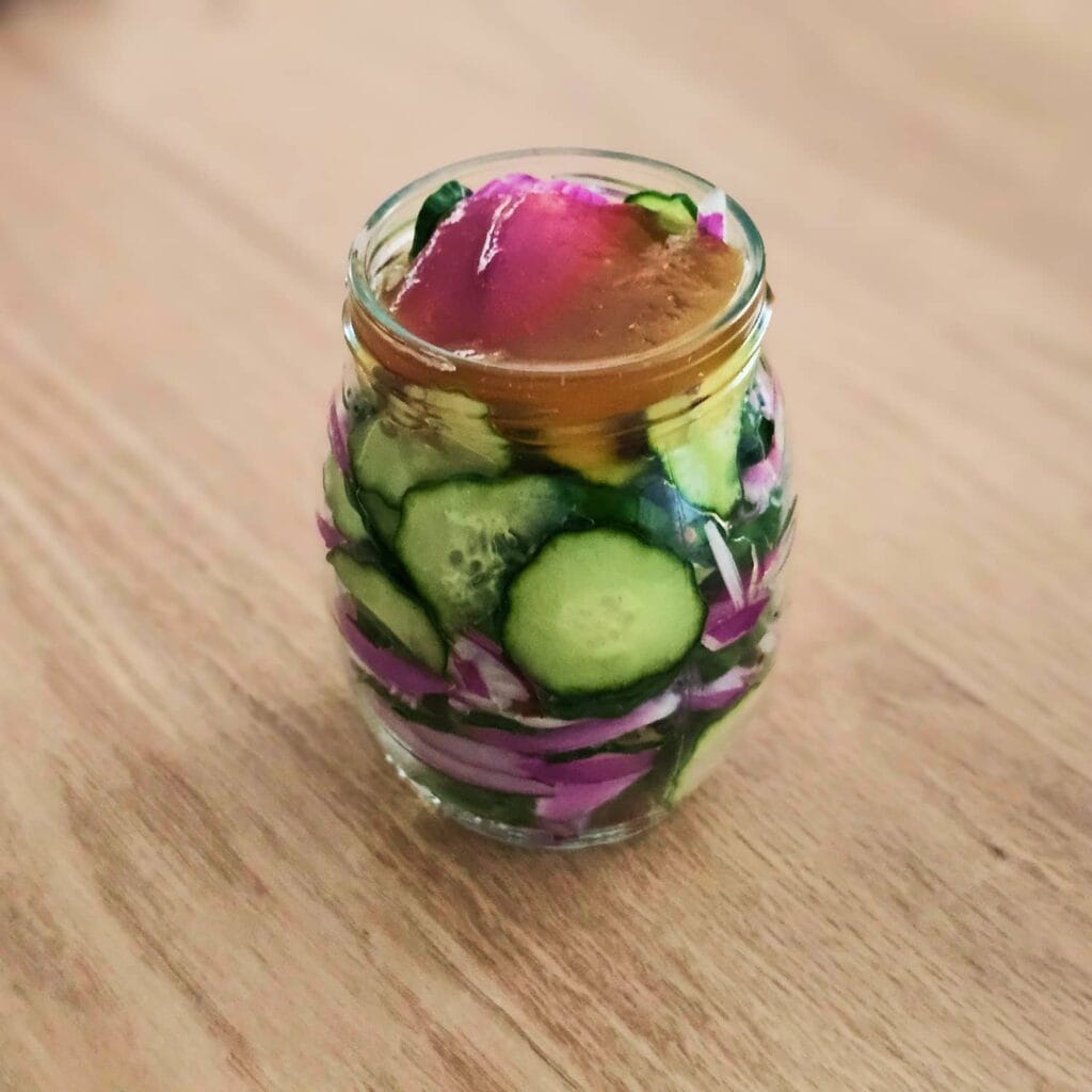 Prération d'un bocal de mini concombres marinés au vinaigre et au miel